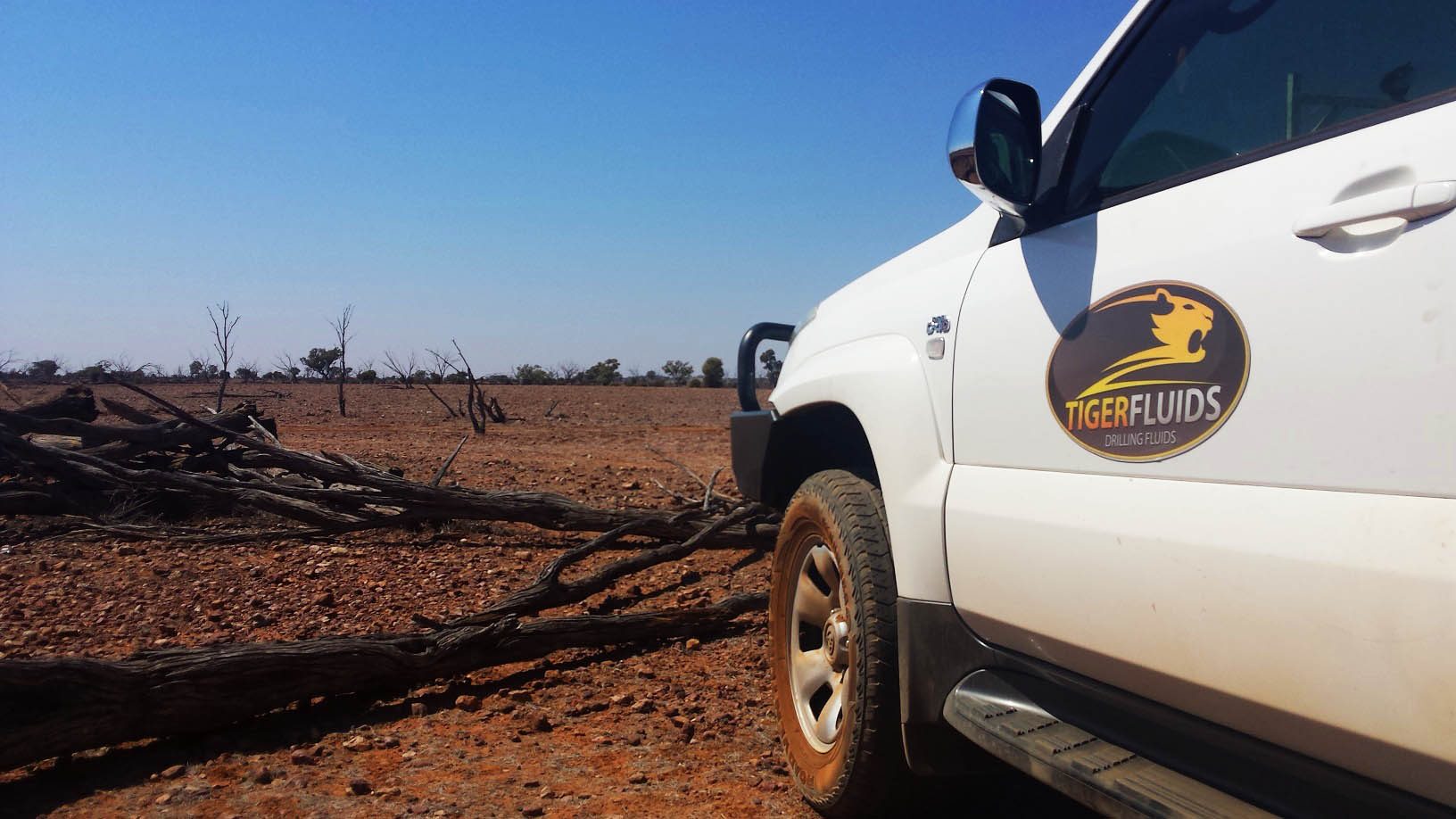 Tiger Fluids vehicle on red dirt at a remote drill site